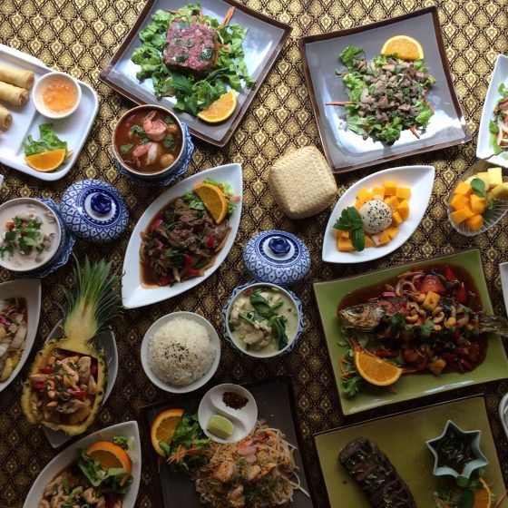 Jolie table avec plein de plats de cuisine thaïlandaise.
